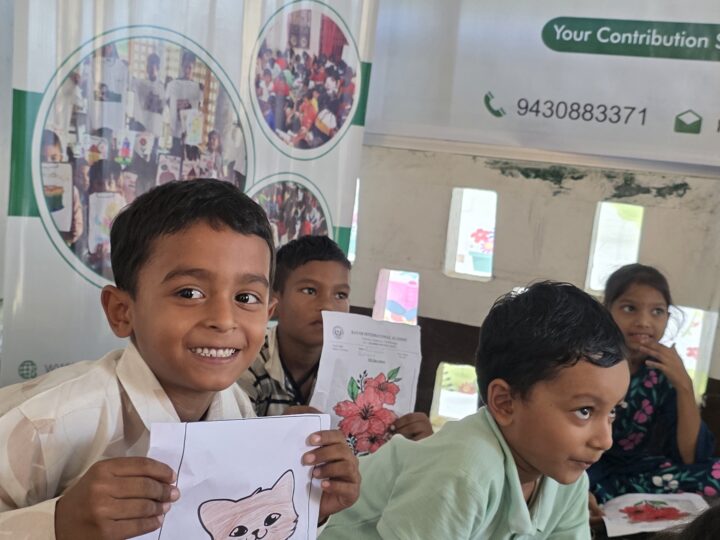 Boy smiling with his drawing at the Build a School day