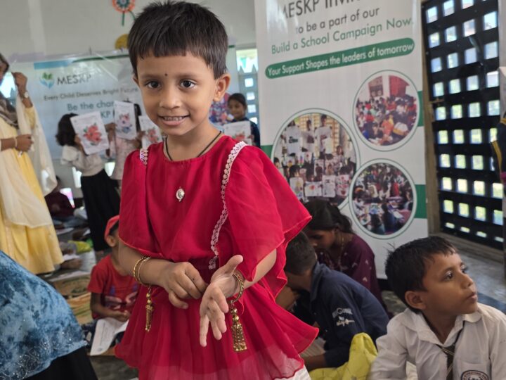 Girl in a red dress at the Build a School drawing day