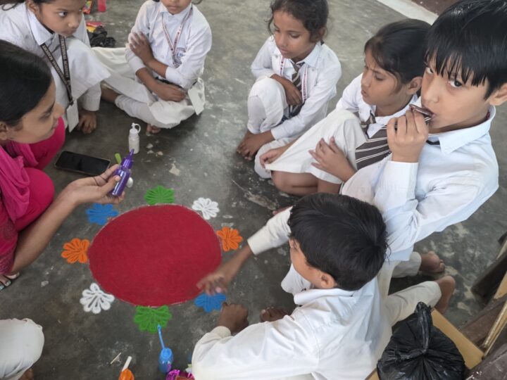 Children making a rangoli on the floor