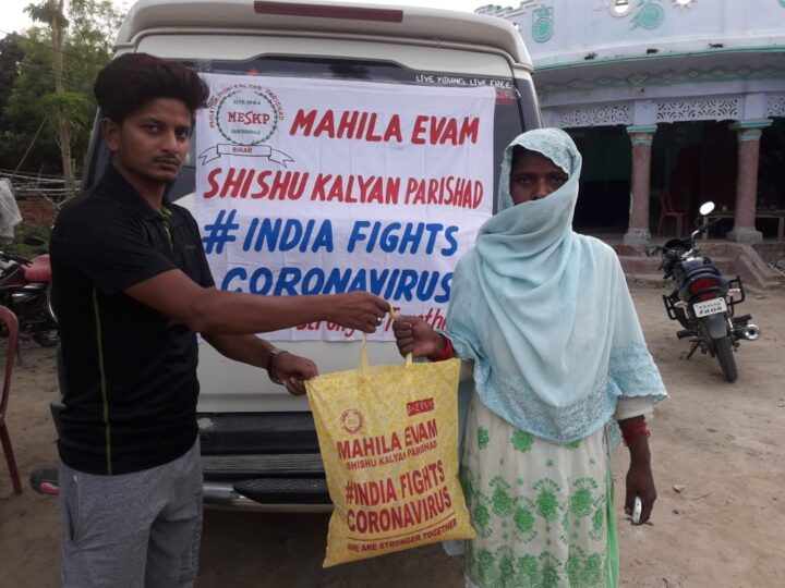 MESKP volunteer handing a relief kit to a family during COVID-19