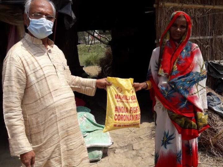 MESKP volunteer handing a relief kit to a family during COVID-19