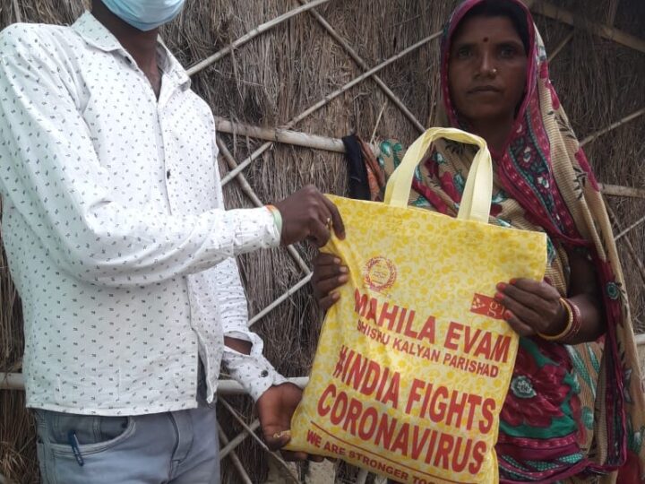 MESKP volunteer handing a relief kit to a family during COVID-19