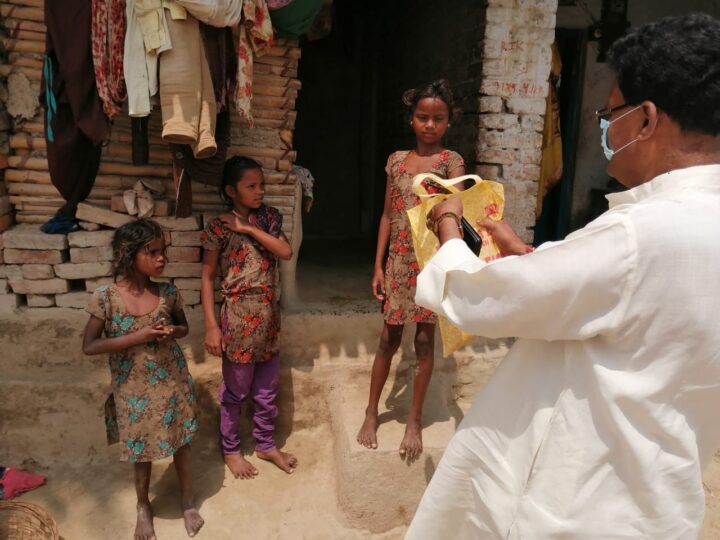 MESKP volunteer handing a relief kit to a family during COVID-19