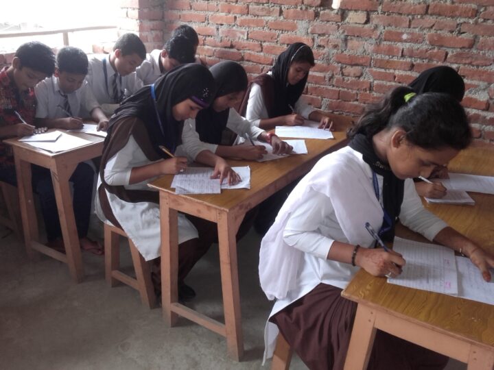 Girls writing an exam at their desks
