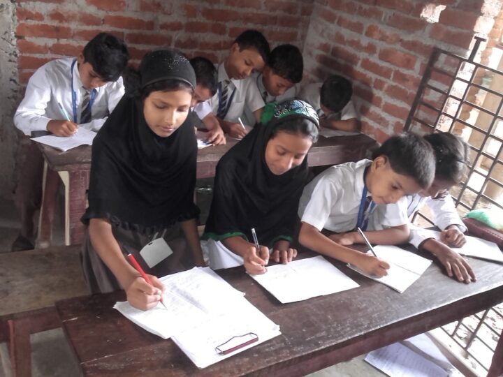 Girls writing an exam in one of our early classrooms