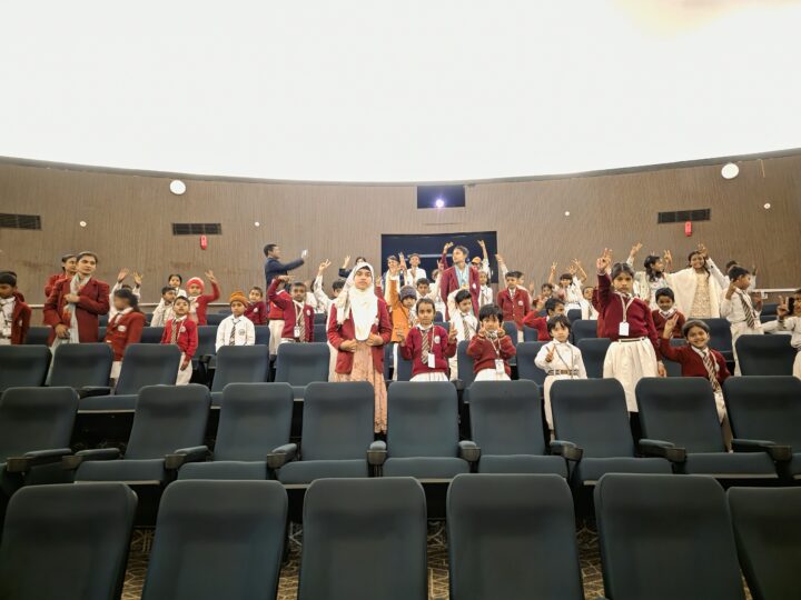 Students in an auditorium on the trip
